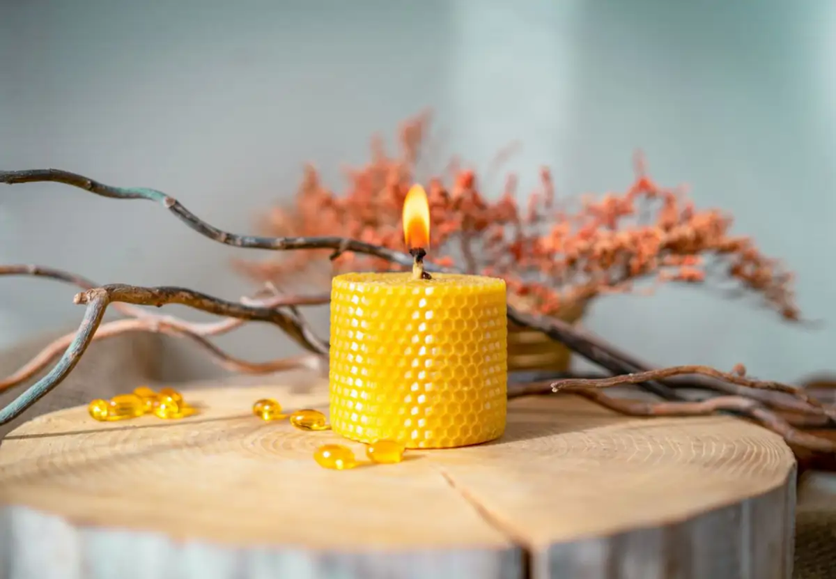 Vela de miel encendida en altar con cuarzo citrino y canela para ritual de abundancia los días 11 y 22